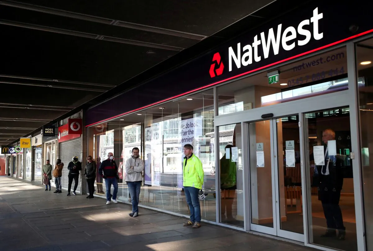 People maintain social distance while they queue outside a Natwest bank as the spread of the coronavirus disease (COVID-19) continues, in London, Britain, on March 26, 2020. (Hannah McKay/Reuters)