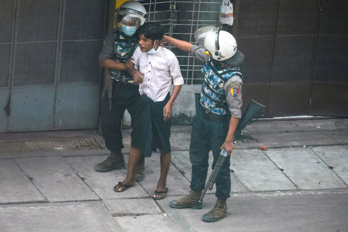 Riot police officers detain a demonstrator during a protest against the military coup in Yangon, Burma, on March 19, 2021. (Stringer/Reuters)