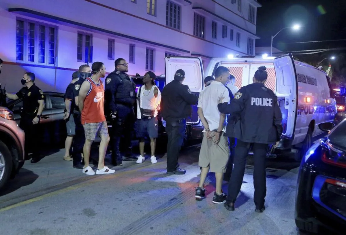 City of Miami Beach Police officers arrest several males on Ocean Drive and 10th Street as spring break has officially begun Saturday, Feb. 20, 2021 in Miami Beach, Fla. Miami Beach officials are imposing an emergency 8 p.m.-6 a.m. curfew effective immediately, saying large, out-of-control spring break crowds crammed the beaches, trashed some restaurant properties and brawled in the streets. Tourists and hotel guests are being told to stay indoors during the curfew hours. (Pedro Portal/Miami Herald via AP)
