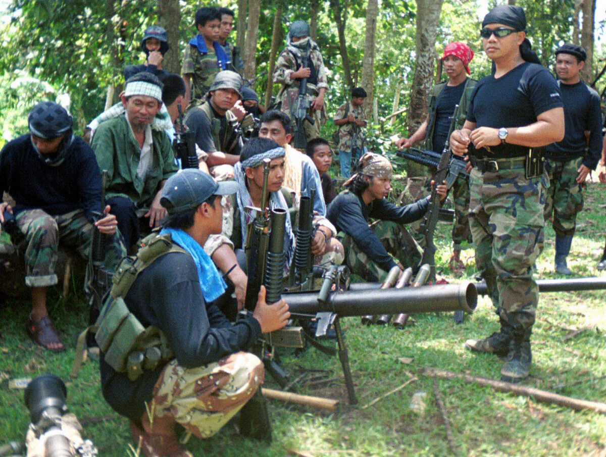 Abu Sayyaf spokesman Abu Sabaya, right foreground, is seen with his band of armed extremists. Philippine troops captured an Abu Sayyaf rebel commander blamed for years of ransom kidnappings and rescued the last of his four Indonesian captives on Sunday, March 21, 2021. (AP Photo, File)