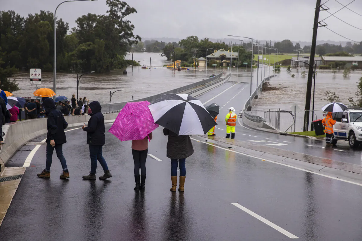 People look on as flood water rises over the New Windsor Bridge on The Hawkesbury River in Windsor in Sydney, Australia on March 21, 2021 . (Jenny Evans/Getty Images)