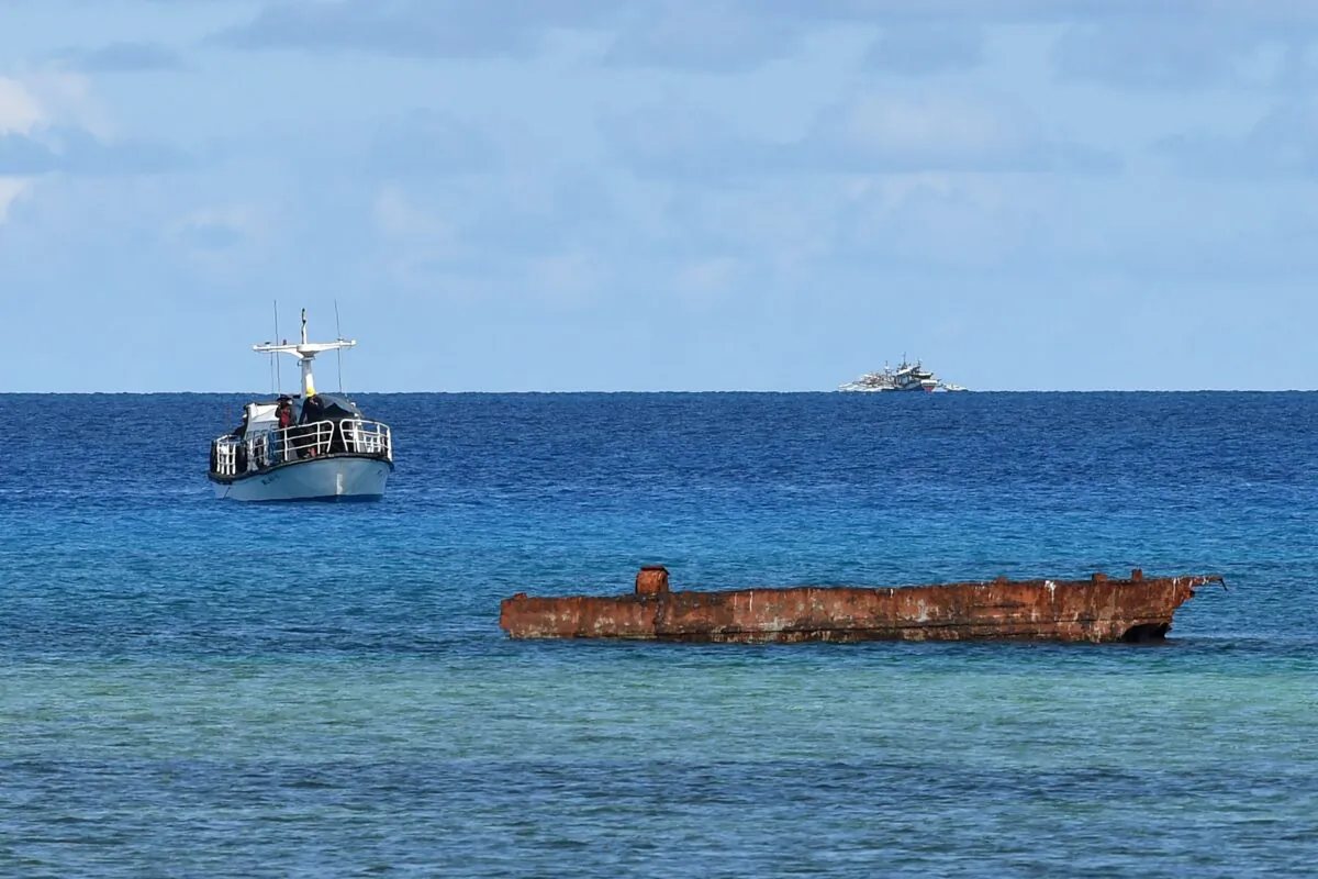 A research boat (L) and Filipino fishing boat (back R) anchored near Thitu island in the disputed Spratly islands of the South China Sea on April 21, 2017. (TED ALJIBE/AFP via Getty Images)