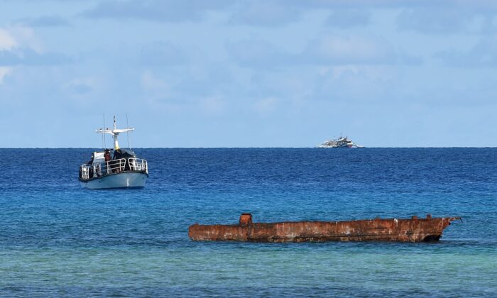 A research boat (L) and Filipino fishing boat (back R) anchored near Thitu island in the disputed Spratly islands of the South China Sea on April 21, 2017. (TED ALJIBE/AFP via Getty Images)