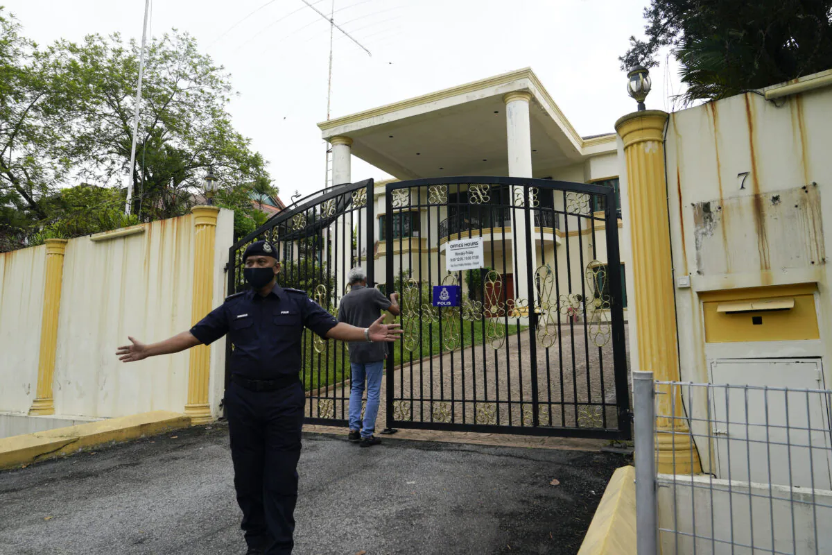 A staff locks the front gate of North Korean embassy in Kuala Lumpur, Sunday, March 21, 2021. (Vincent Thian/AP)