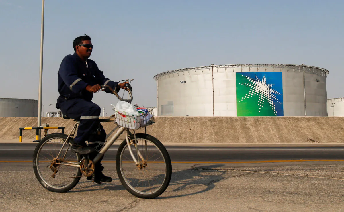 An employee rides a bicycle next to oil tanks at Saudi Aramco oil facility in Abqaiq, Saudi Arabia, on Oct. 12, 2019. (Maxim Shemetov/Reuters)