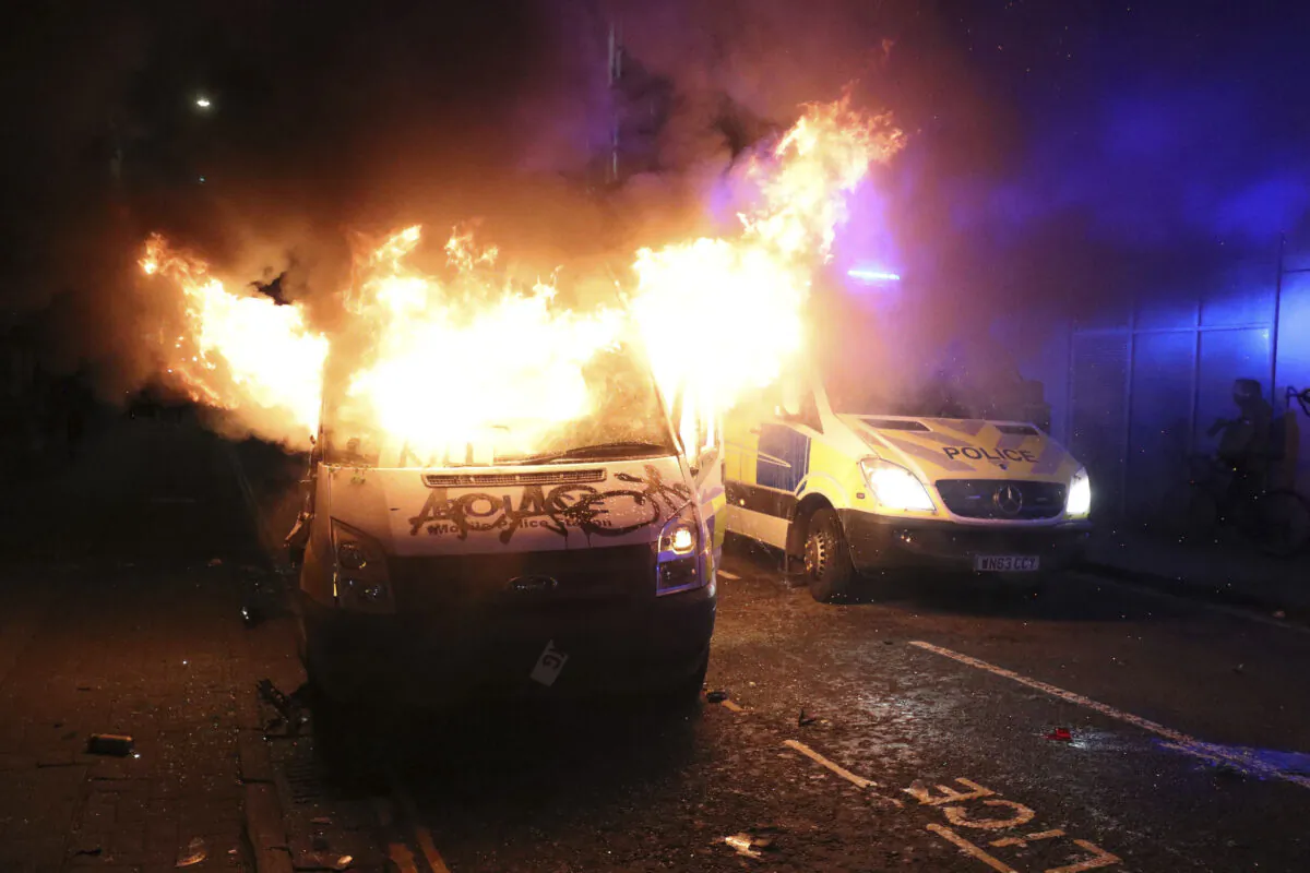 A vandalised police van on fire outside Bridewell Police Station, in Bristol, England, on March 21, 2021. (Andrew Matthews/PA via AP)