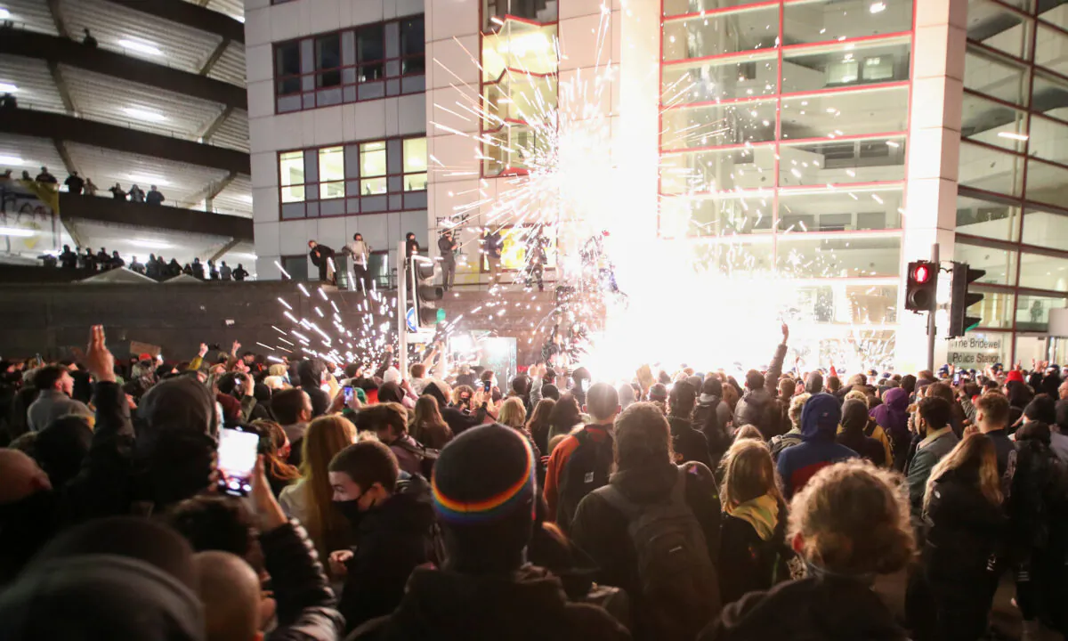 Demonstrators launch fireworks at police officers during a protest against a new proposed policing bill, in Bristol, Britain, on March 21, 2021. (Peter Cziborra/Reuters)