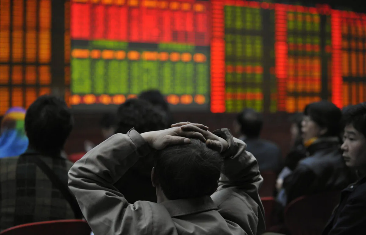 Investors watch an electronic board showing stock prices at a securities brokerage in Beijing on March 20, 2008. (Peter Parks/AFP via Getty Images)
