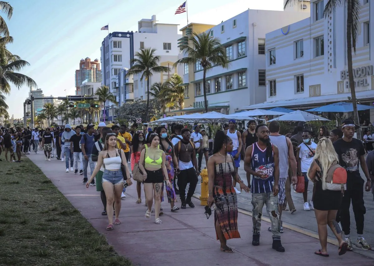 Spring break tourists walk alongside Ocean Drive in Miami Beach, Fla., on March 21, 2021. (Carl Juste/Miami Herald via AP)