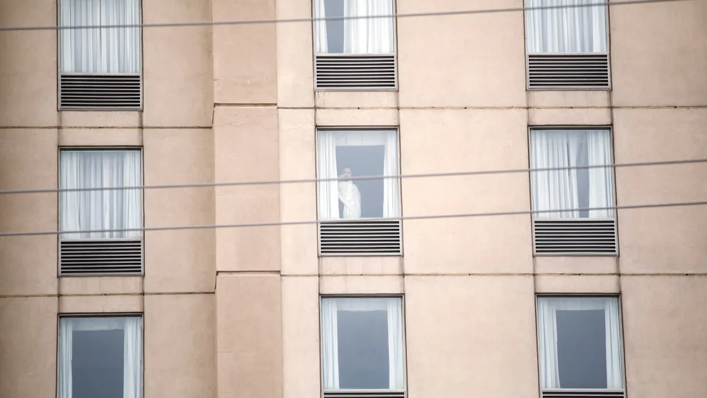 A guest is seen in a hotel window in Mississauga, Ont. by the Pearson International Airport on Feb. 22, 2021 as new air travel rules come into effect in Canada. (Cole Burston / The Canadian Press)
