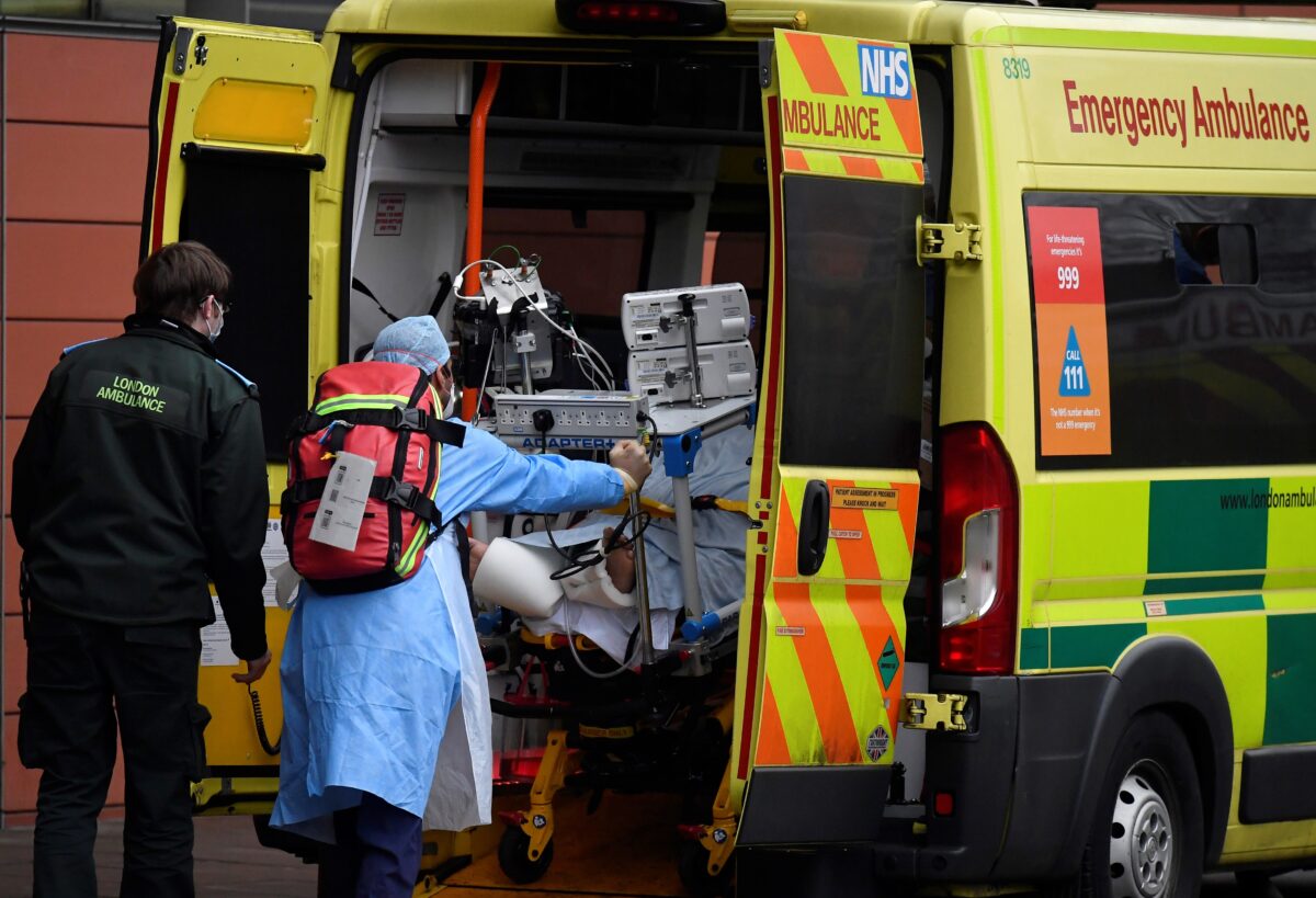 Medical workers move a patient between ambulances outside of the Royal London Hospital amid the spread of the coronavirus disease (COVID-19) pandemic, London