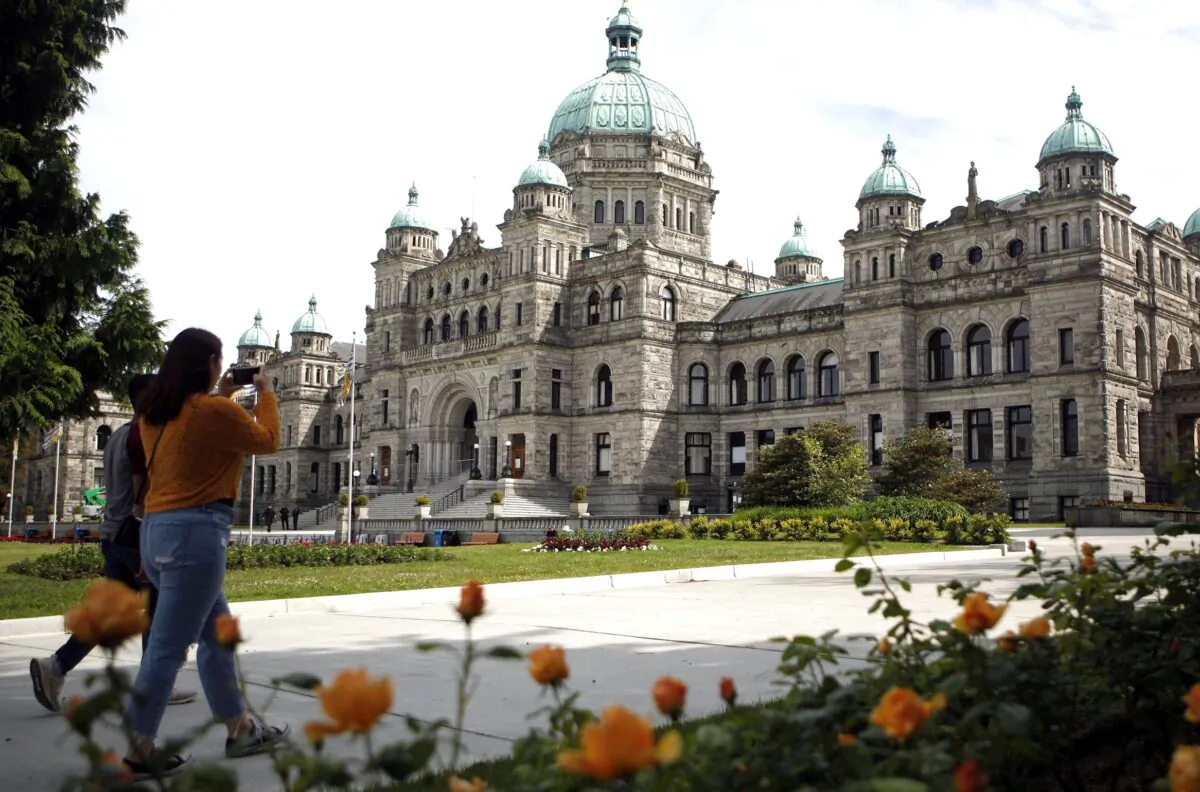 People walk past the B.C. legislature in Victoria, B.C., on June 10, 2020. (The Canadian Press/Chad Hipolito)