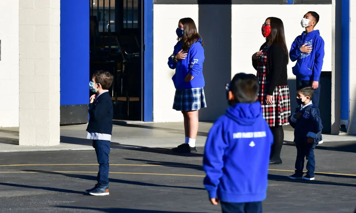 Students stand at attention as the national flag is raised at St. Joseph Catholic School in La Puente, Calif., on Nov. 16, 2020.  (Frederic J. Brown/AFP via Getty Images)