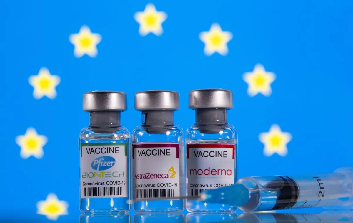 Vials with Pfizer-BioNTech, AstraZeneca, and Moderna COVID-19 vaccine labels stand in front of a European Union flag on March 19, 2021. (Dado Ruvic/Illustration/Reuters)