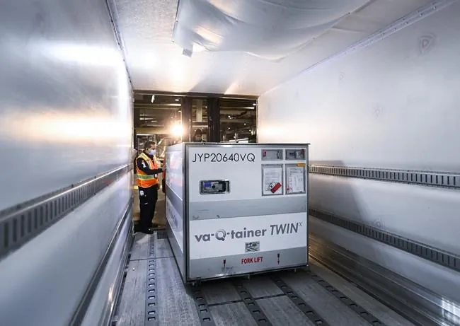 A FedEx worker loads the 255,600 doses of the Moderna COVID‑19 vaccine which came from Europe into a freezer trailer to be transported during the COVID-19 pandemic at Pearson International Airport in Toronto on March 24, 2021. (Nathan Denette / The Canadian Press) 