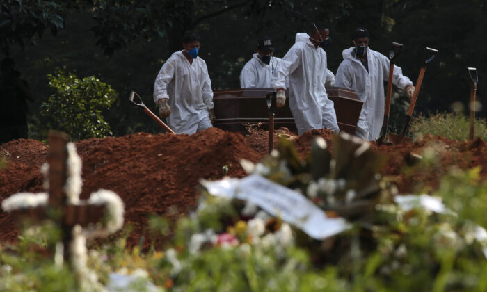 Cemetery workers carry the coffin of a victim of COVID-19 at the Vila Formosa cemetery in Sao Paulo, Brazil on March 23, 2021. (Miguel Schincariol/AFP via Getty Images)