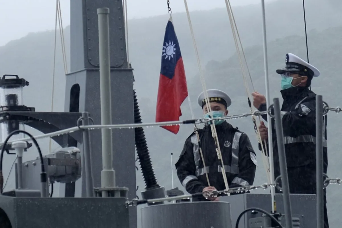 Two navy sailors raise Taiwan's national flag during an official ceremony at a shipyard in Su'ao, a township in eastern Taiwan's Yilan County, on Dec. 15, 2020. (Sam Yeh/AFP via Getty Images)