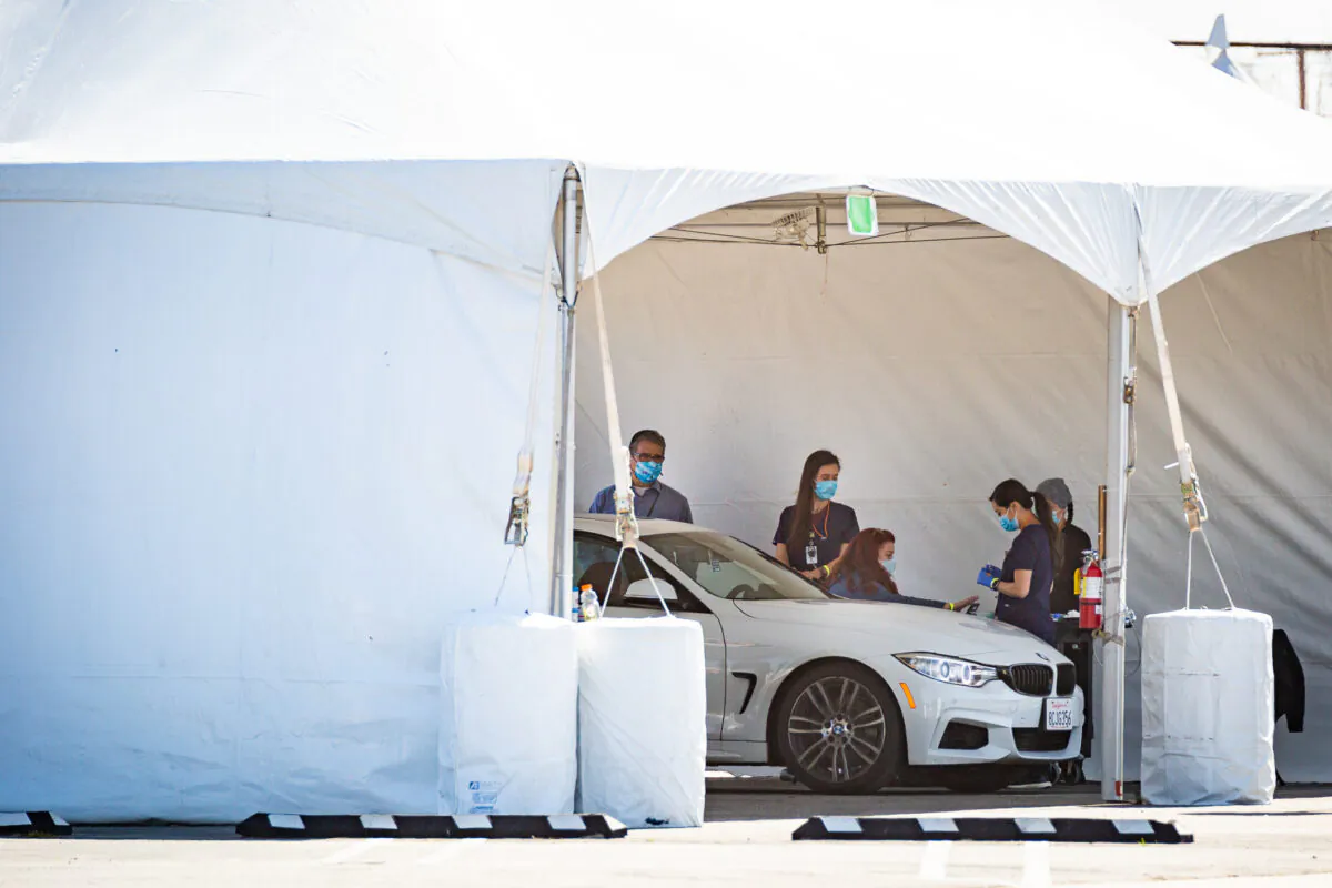 Medical workers prepare to administer a COVID-19 vaccination at a drive-thru site at Santa Ana College in Santa Ana, Calif., on Feb. 17, 2021. (John Fredricks/The Epoch Times)