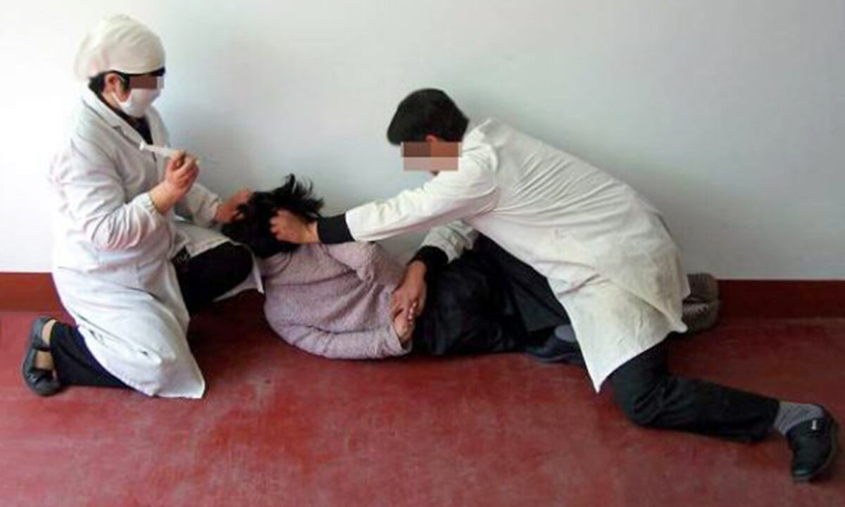 A reenactment of a Falun Gong adherent being forcibly injected with psychiatric drugs. Psychiatric abuse is a common method of persecution in China to coerce people to give up their faith. (Courtesy of Minghui.org)