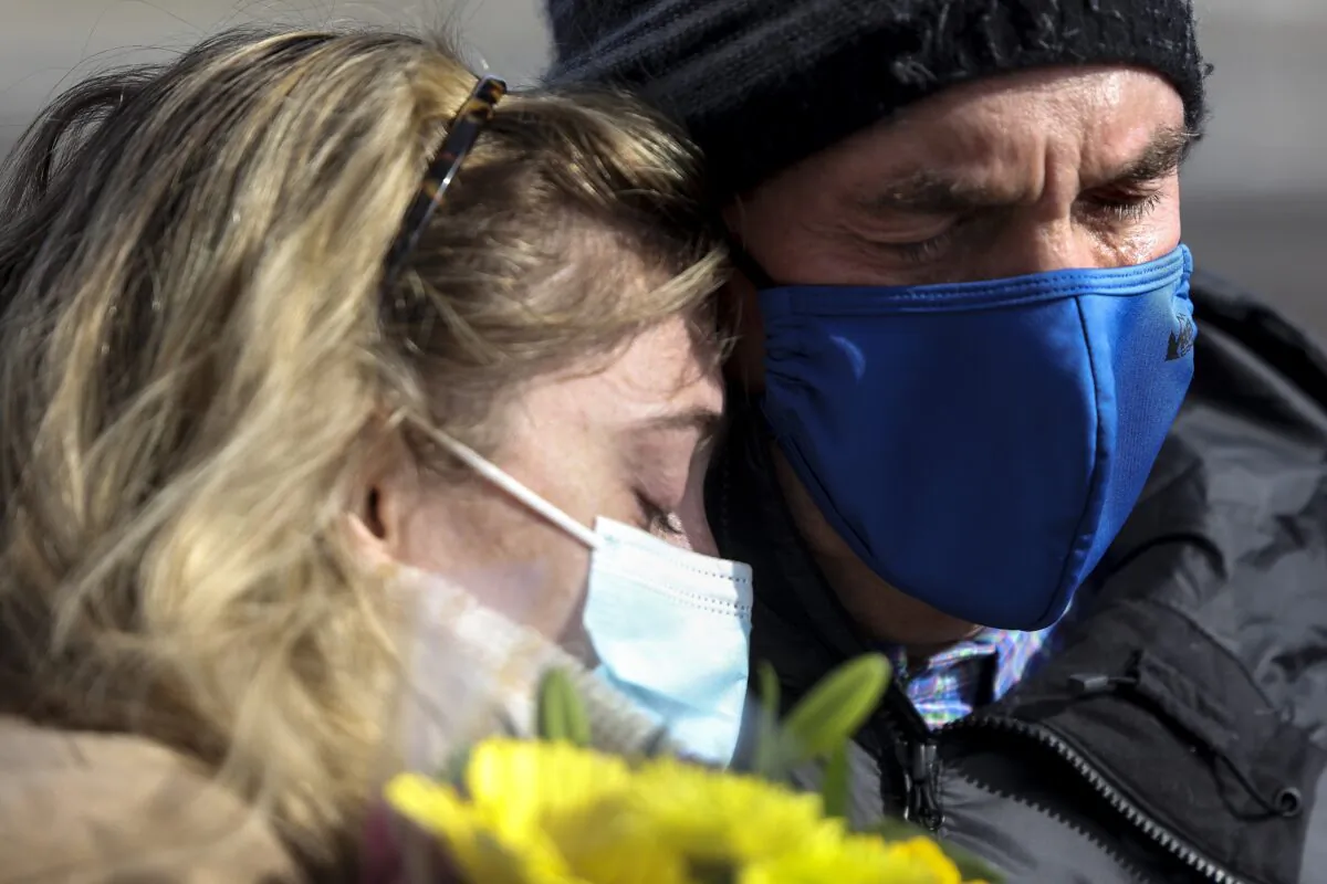 A father and daughter comfort each other at a makeshift memorial for the victims of a mass shooting outside a King Soopers grocery store in Boulder, Colo., on March 24, 2021. (Michael Ciaglo/Getty Images)