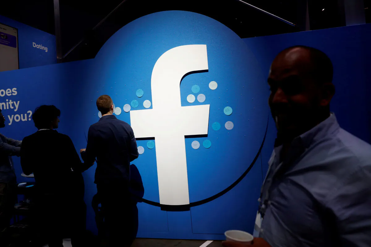 Attendees walk past a Facebook logo during Facebook Inc's F8 developers conference in San Jose, California, April 30, 2019. (Reuters/Stephen Lam/File Photo)