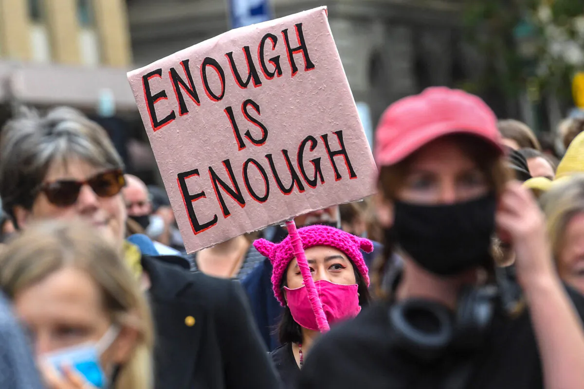 A woman holds up a placard during a protest against sexual violence and gender inequality in Melbourne on March 15, 2021. (William West / AFP)