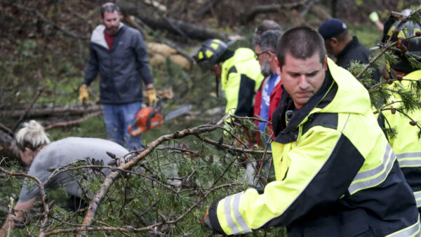 A firefighter works with residents to remove fallen trees blocking roads for rescue crews to get past after a tornado touched down south of Birmingham, Ala. in the Eagle Point community damaging multiple homes on March 25, 2021. (Butch Dill/AP Photo) ‘Significant Damage’