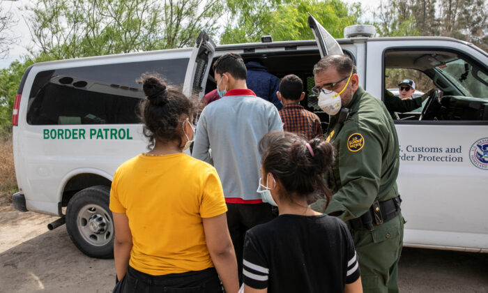 Unaccompanied minors are loaded into a U.S. Border Patrol transport van after crossing the U.S.-Mexico border, in Hildalgo, Texas, on March 25, 2021. (John Moore/Getty Images)