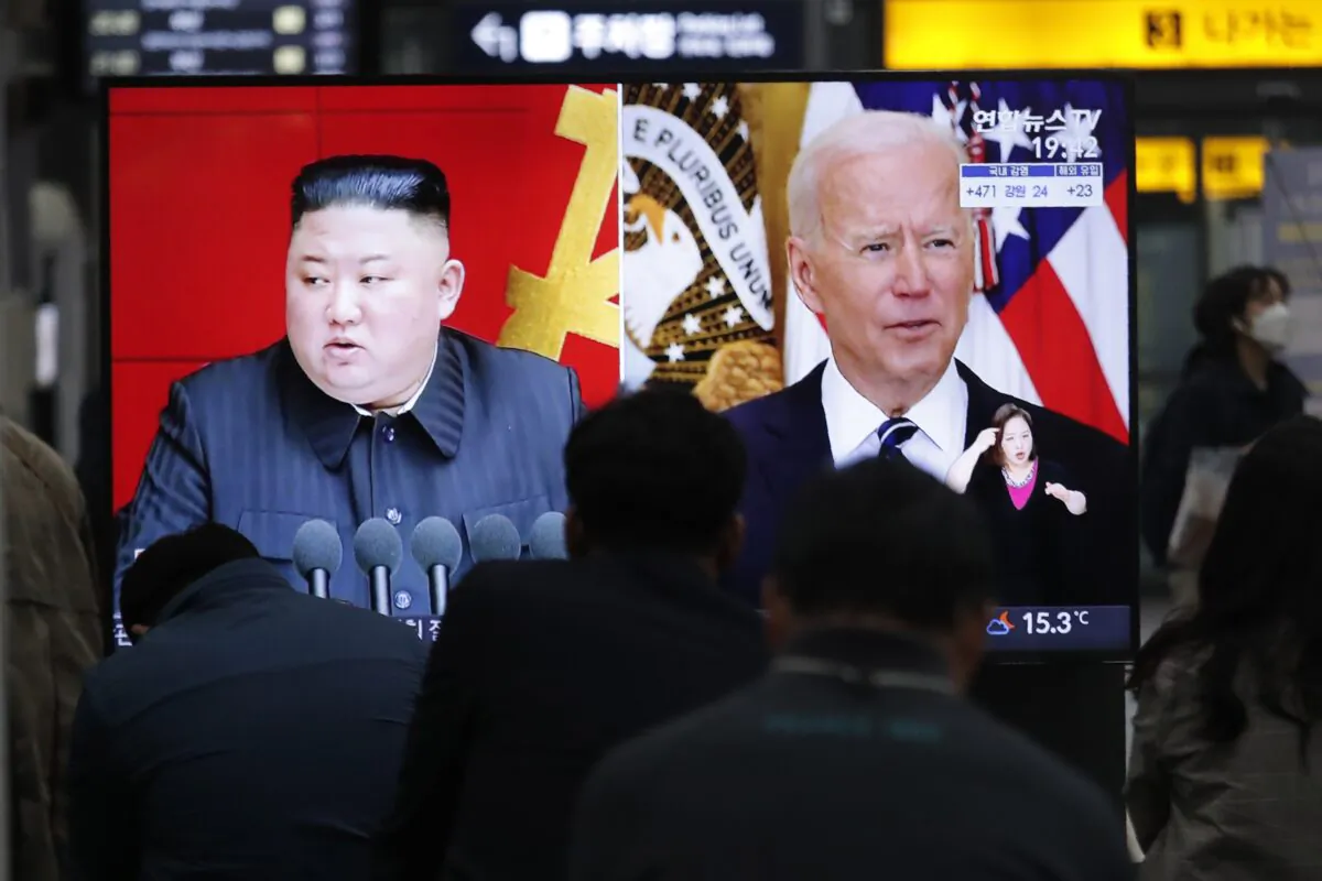 Commuters watch a TV showing a file image of North Korean leader Kim Jong Un and U.S. President Joe Biden during a news program at the Suseo Railway Station in Seoul, South Korea, on March 26, 2021. (Ahn Young-joon/AP Photo)