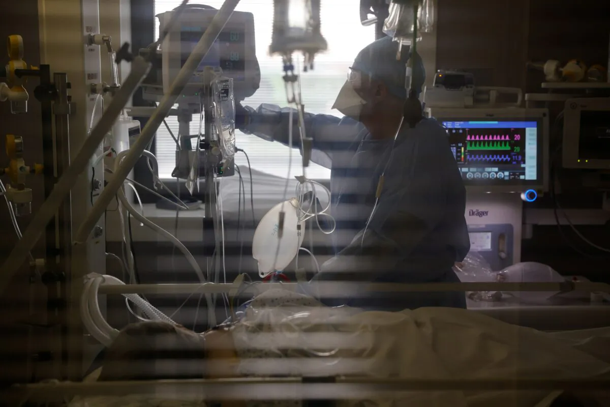Medical worker wearing protective gear works in the Intensive Care Unit (ICU) where people suffering from CCP virus disease (COVID-19) are treated at Cambrai hospital, France, on March 25, 2021. (Pascal Rossignol/Reuters)