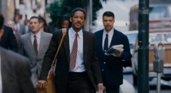 Will Smith in suit walking on crowded sidewalk