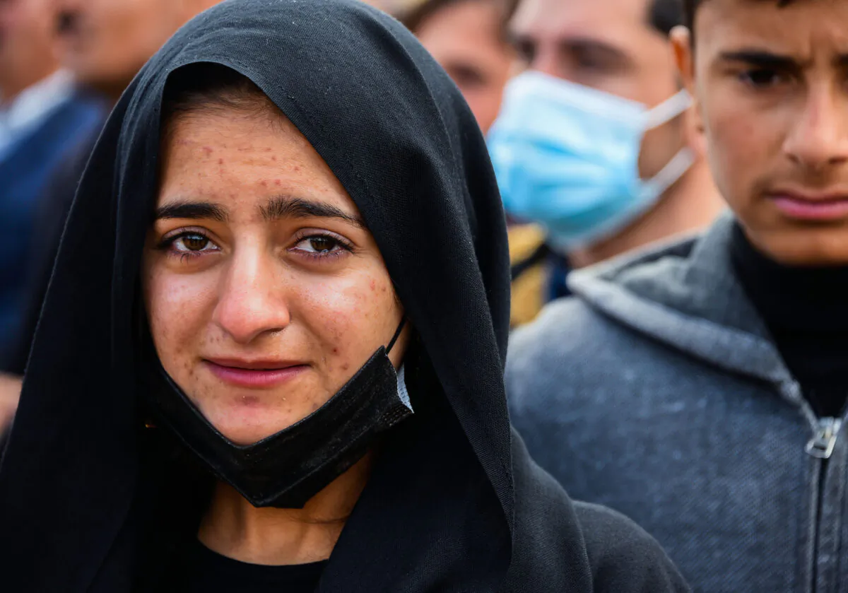 A woman reacts during a a mass funeral for Yezidi victims of the Islamic State (ISIS) group in the northern Iraqi village of Kojo in Sinjar district, on Feb. 6, 2021. (Zaid al-Obeidi/AFP via Getty Images)