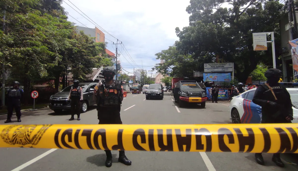 Armed police officers stand guard along a closed road following an explosion outside a Catholic church in Makassar, South Sulawesi Province, Indonesia, on March 28, 2021. (Stringer/Reuters)