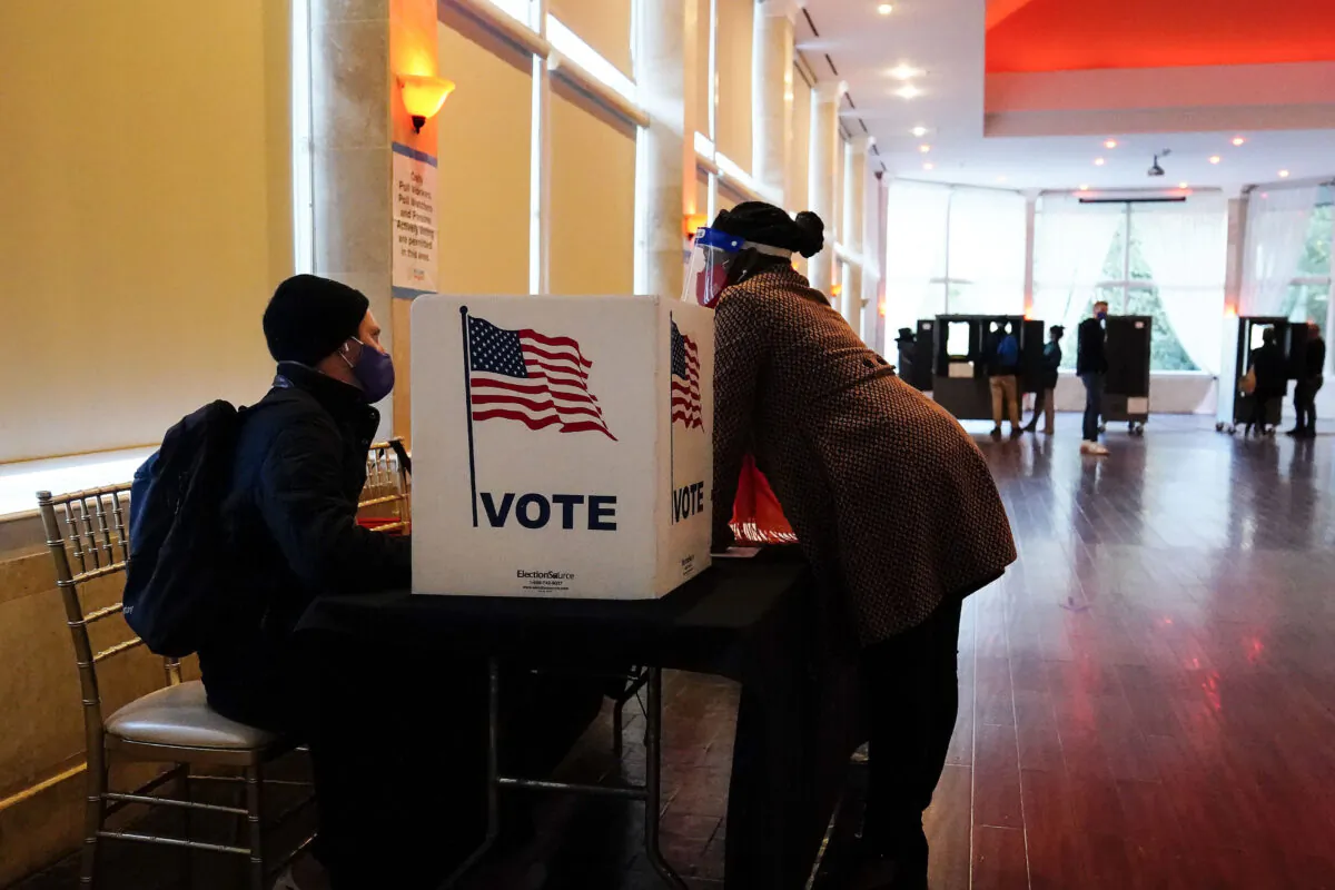 A poll worker talks to a voter before they vote on a paper ballot in Georgia. (Brynn Anderson/AP Photo)