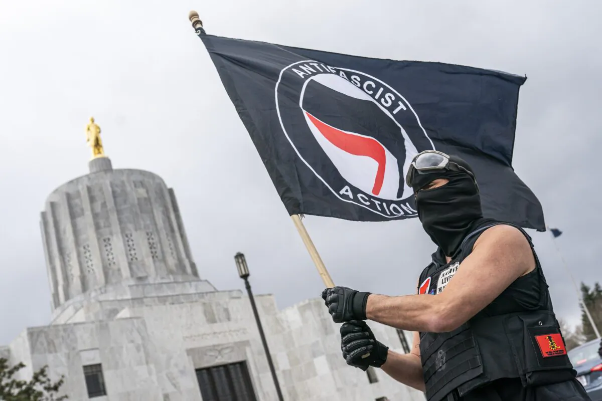A man waves an Antifa flag at the Oregon statehouse in Salem, Ore., on March 28, 2021. (Nathan Howard/Getty Images)