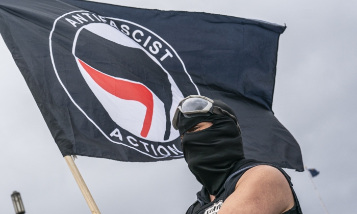 A man holds an Antifa flag at the Oregon statehouse in Salem, Ore., on March 28, 2021. (Nathan Howard/Getty Images)