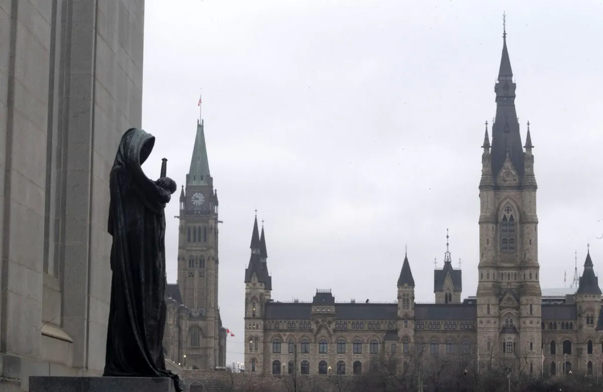 The justice statue at the Supreme Court of Canada, with the Parliament Buildings in the background, in Ottawa on March 25, 2021. (The Canadian Press/Adrian Wyld)