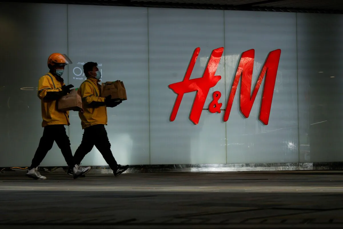 People walk past an H&M store in a shopping area in Beijing, China on March 28, 2021. (Thomas Peter/Reuters)