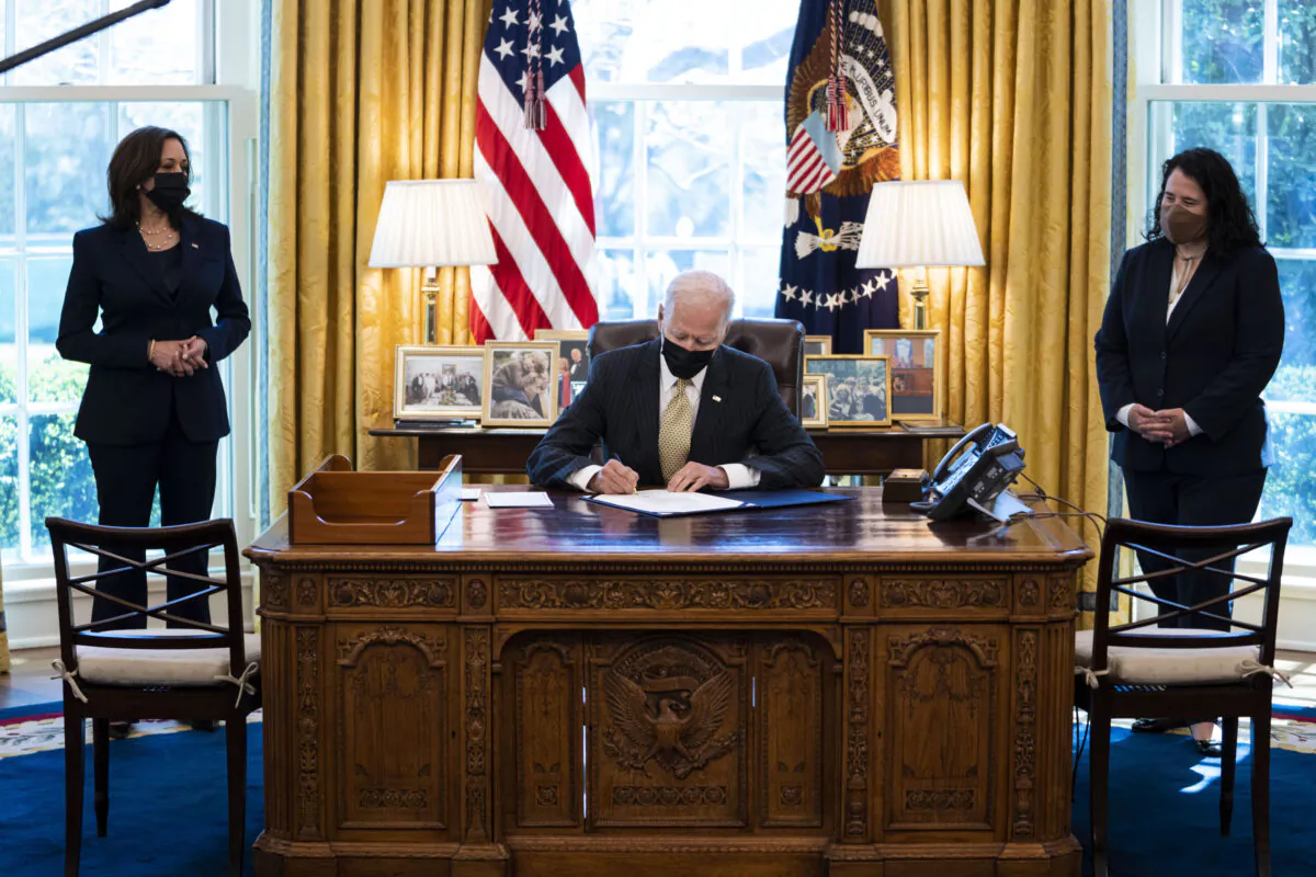 Flanked by Vice President Kamala Harris (L) and Administrator of the Small Business Administration (SBA) Isabella Casillas Guzman (R), U.S. President Joe Biden signs the Paycheck Protection Program (PPP) extension in the Oval Office of the White House in Washington, on March 30, 2021. (Doug Mills-Pool/Getty Images)