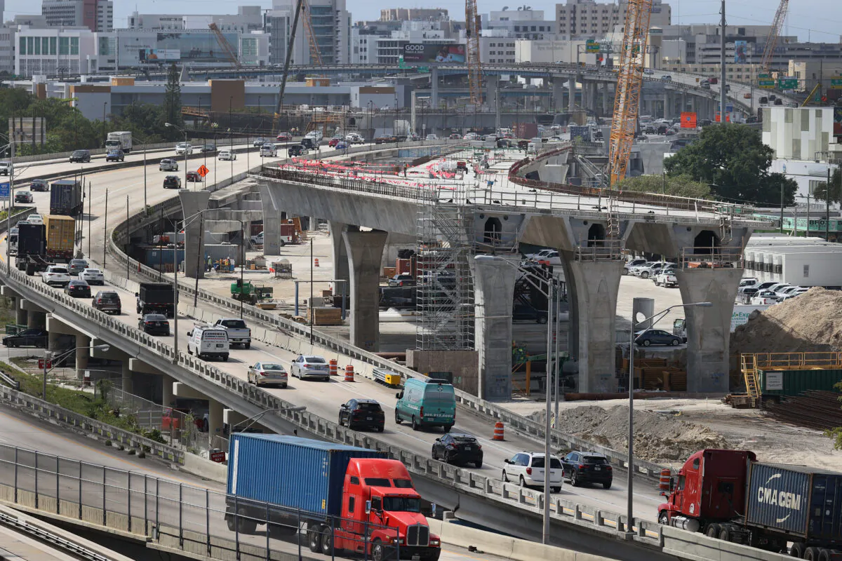 Construction workers build the “Signature Bridge,” replacing and improving a busy highway intersection at I-95 and I-395 in Miami on March 17, 2021. (Joe Raedle/Getty Images)