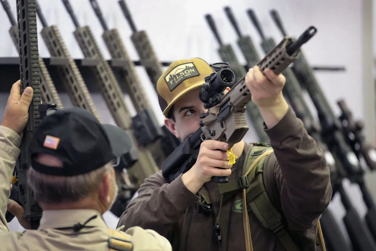 Guests look over rifle scopes in a booth at the NRA convention in Indianapolis, Ind., on April 27, 2019. (Scott Olson/Getty Images)