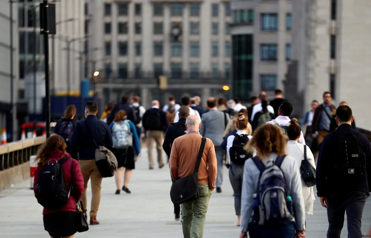 Commuters walk across the London Bridge during the morning rush hour, amid an outbreak COVID-19 in London on Sept. 17, 2020. (Hannah McKay/Reuters)