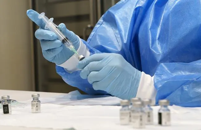 A syringe is prepared with COVID-19 vaccine at a vaccination clinic in Montreal, on March 15, 2021. The two provinces hit hardest by COVID-19 are weighing stricter restrictions amid surging case counts, as health officials and politicians urge Canadians to stay home over the upcoming Easter holiday. (Paul Chiasson / The Canadian Press) 