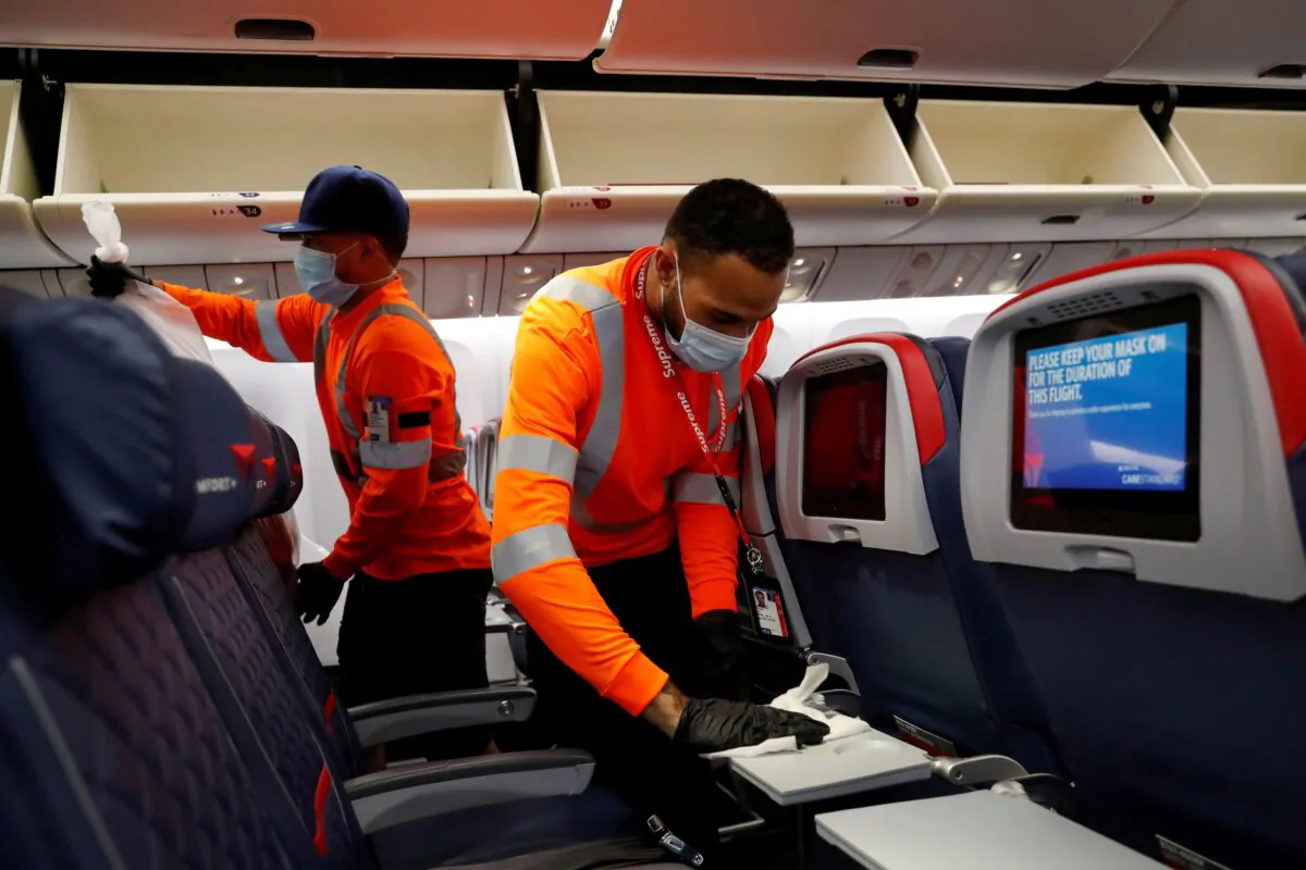 Delta Air Lines pre-flight cleaning crew members work on an aircraft at JFK International Airport, N.Y., on Aug. 6, 2020. (Shannon Stapleton/Reuters)
