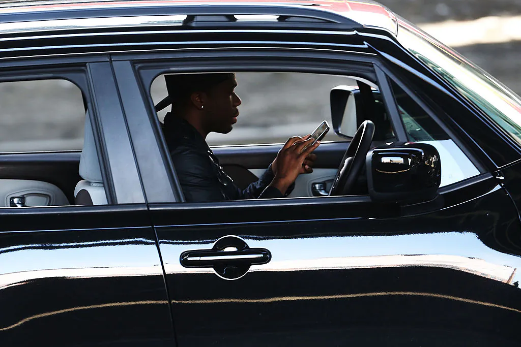 A driver in New York City uses a phone while behind the wheel of a car in this file photo. (Spencer Platt/Getty Images)