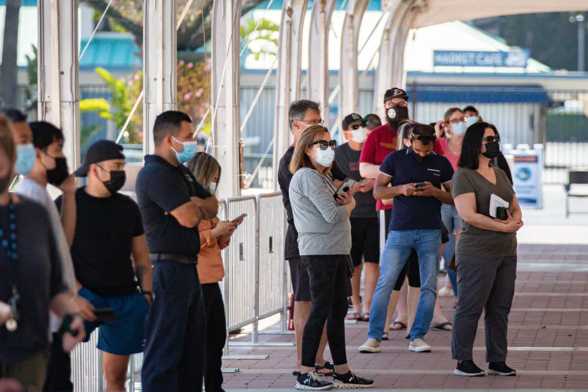 People wait for COVID-19 vaccinations at the opening day of a new vaccination site at the Orange County Fairgrounds in Costa Mesa, Calif., on March 31, 2021. (John Fredricks/The Epoch Times)