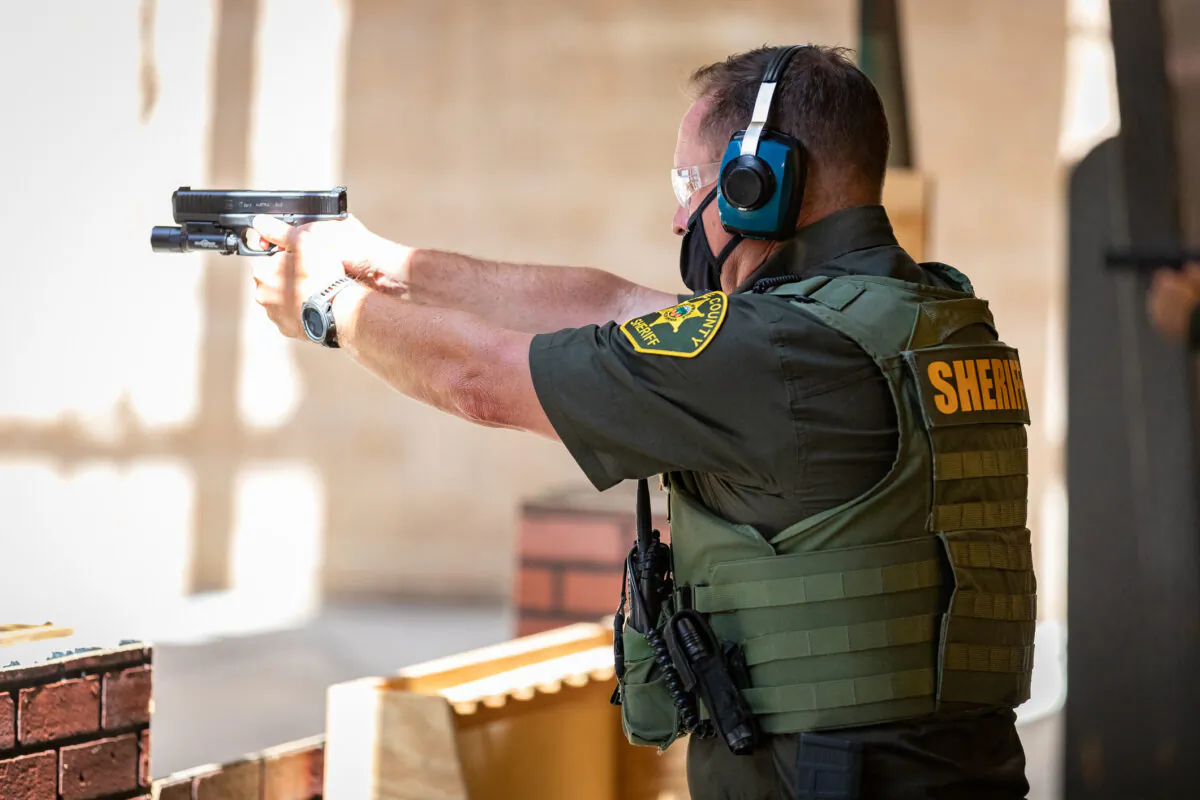 A deputy fires his weapon downrange at the Orange County Sheriff's Department  shooting range in Orange, Calif., on March 30, 2021. (John Fredricks/The Epoch Times)