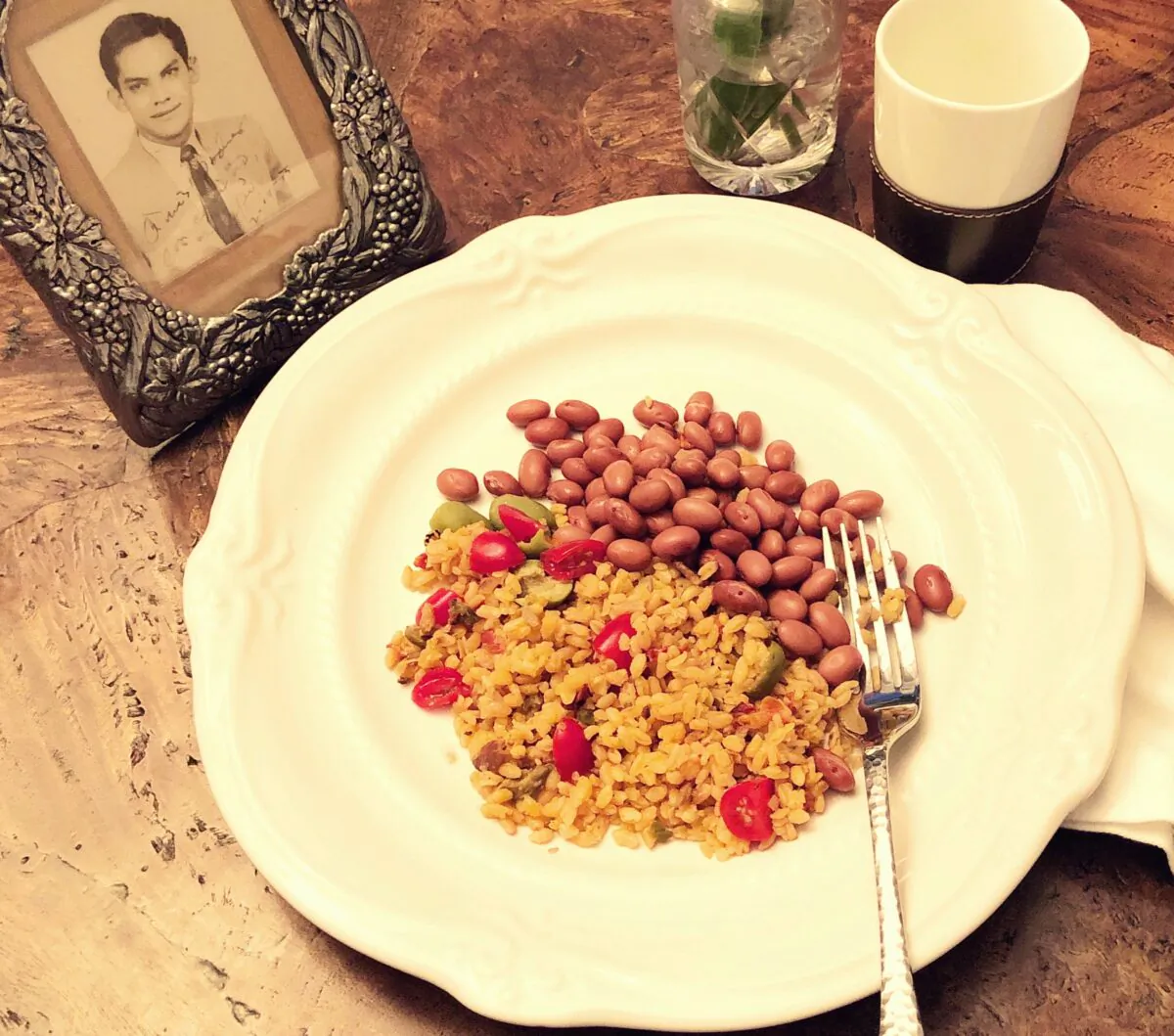The author's father's rice and beans, along with her favorite photo of her father. It includes a sweet inscription to his parents, sent with letters home in 1955. (Courtesy of Cara Colon-McLauchlan)