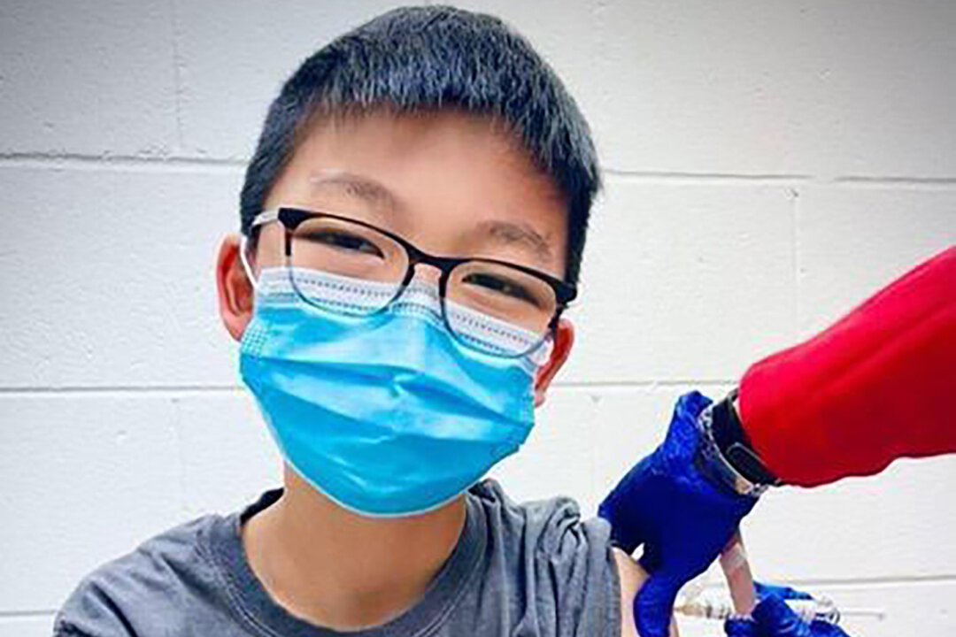 Caleb Chung from the United States receives the first dose of the Pfizer coronavirus vaccine or placebo as a trial participant for kids ages 12-15, at Duke University Health System in Durham, N.C., on Dec. 22, 2020.  (Richard Chung via AP)