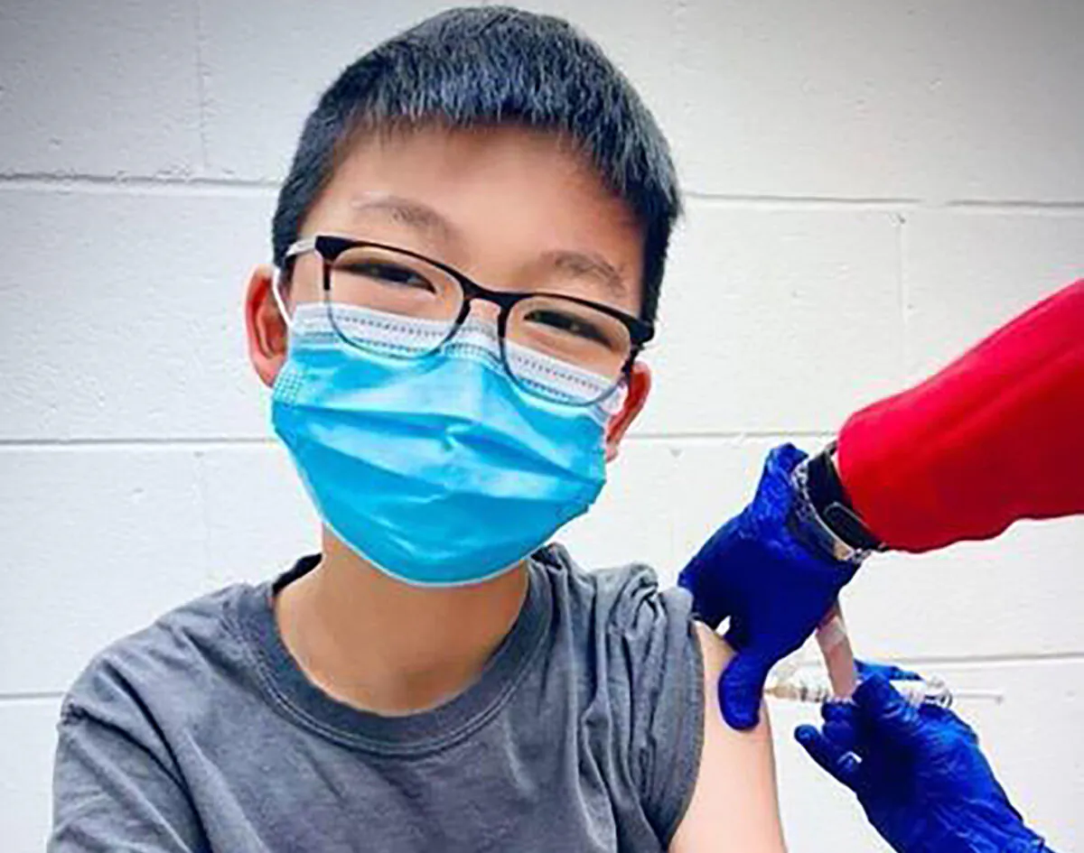 Caleb Chung from the United States receives the first dose of the Pfizer coronavirus vaccine or placebo as a trial participant for kids ages 12-15, at Duke University Health System in Durham, N.C., on Dec. 22, 2020.  (Richard Chung via AP)